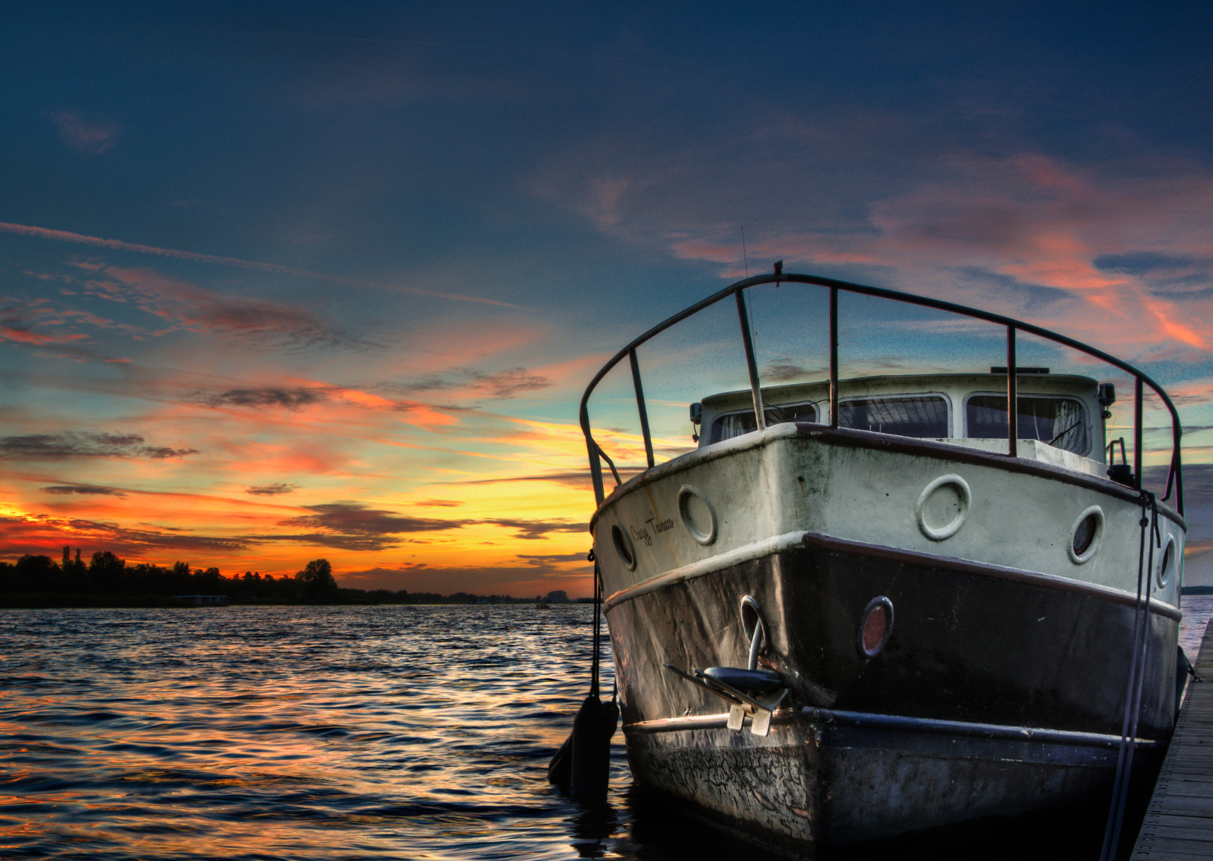 A fishing boat at the dock at sunset