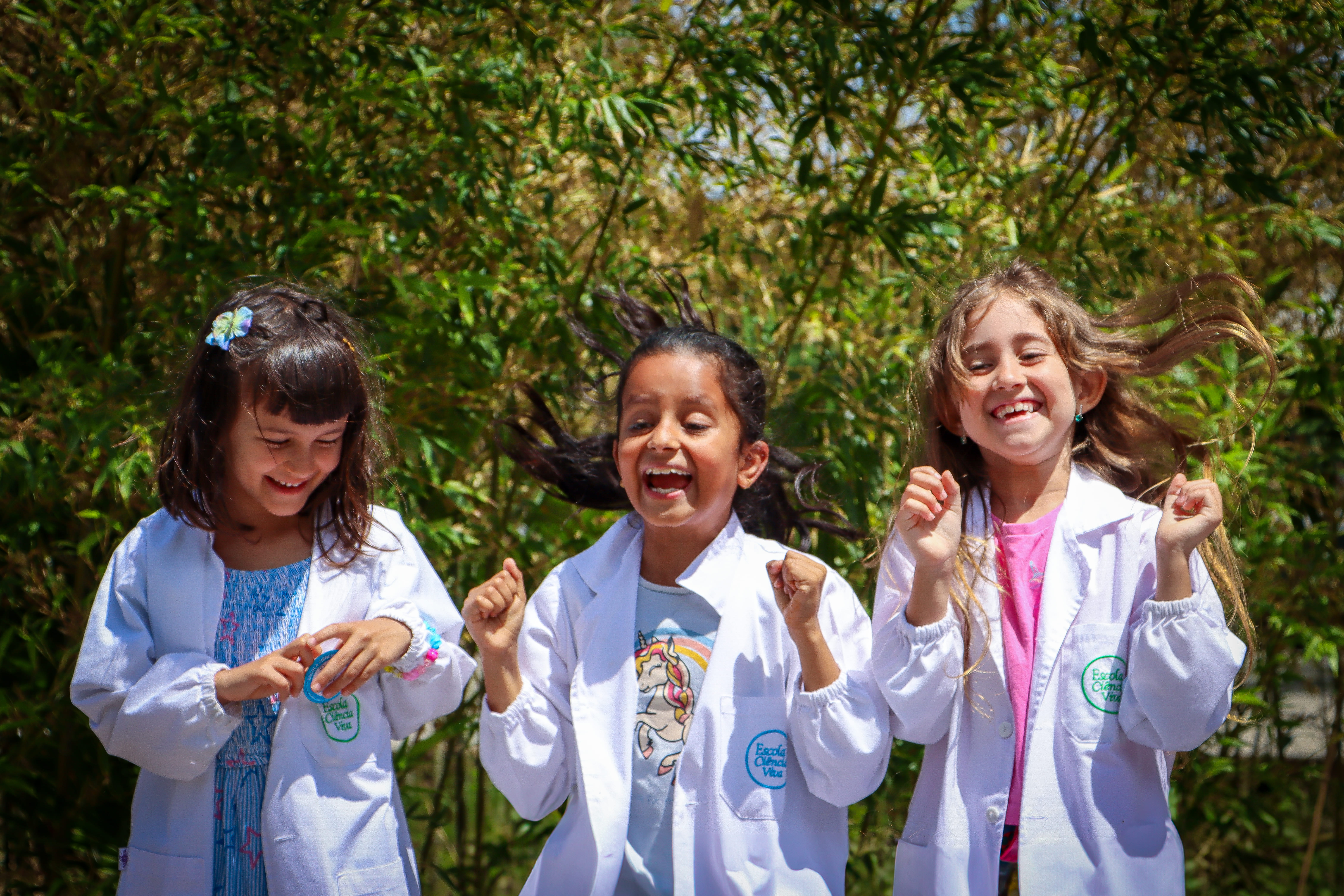 Young students in lab coats smiling